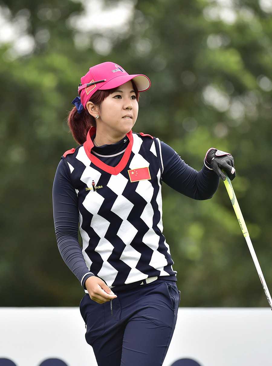 韩国高尔夫女将安信爱站在球道中央，手搭凉棚，正聚精会神地观望远处小白球的飞行路线与落点