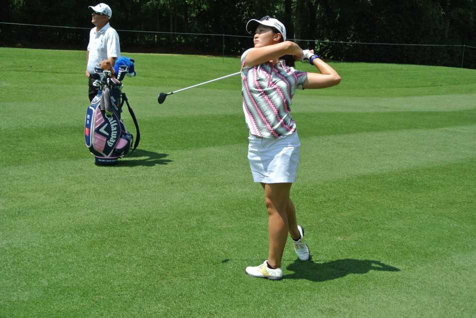 果岭上的戏剧瞬间与竞逐之路 一位女球员沉着自信地准备开球,目光坚定地望向前方广阔的球道