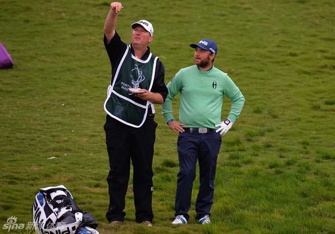 果岭上的策略博弈与专注魅力 球童正迎风而立,神情专注地扬起一把草屑,以此判断风向与风速,为球员的关键一击提供决策依据。