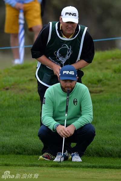 果岭上的策略博弈与专注魅力 一名球员正俯身贴近果岭表面,屏息凝神地观察草纹的细微走向与坡度,进行至关重要的‘看线’。