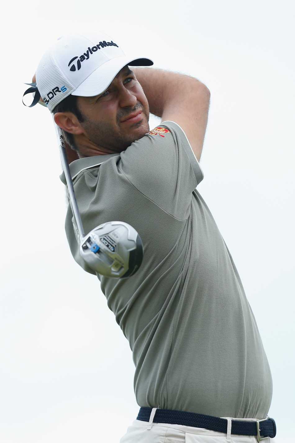 卡皮罗托腮沉思推杆策略，帽檐下眉头微皱，果岭光影交错如一幅抽象画