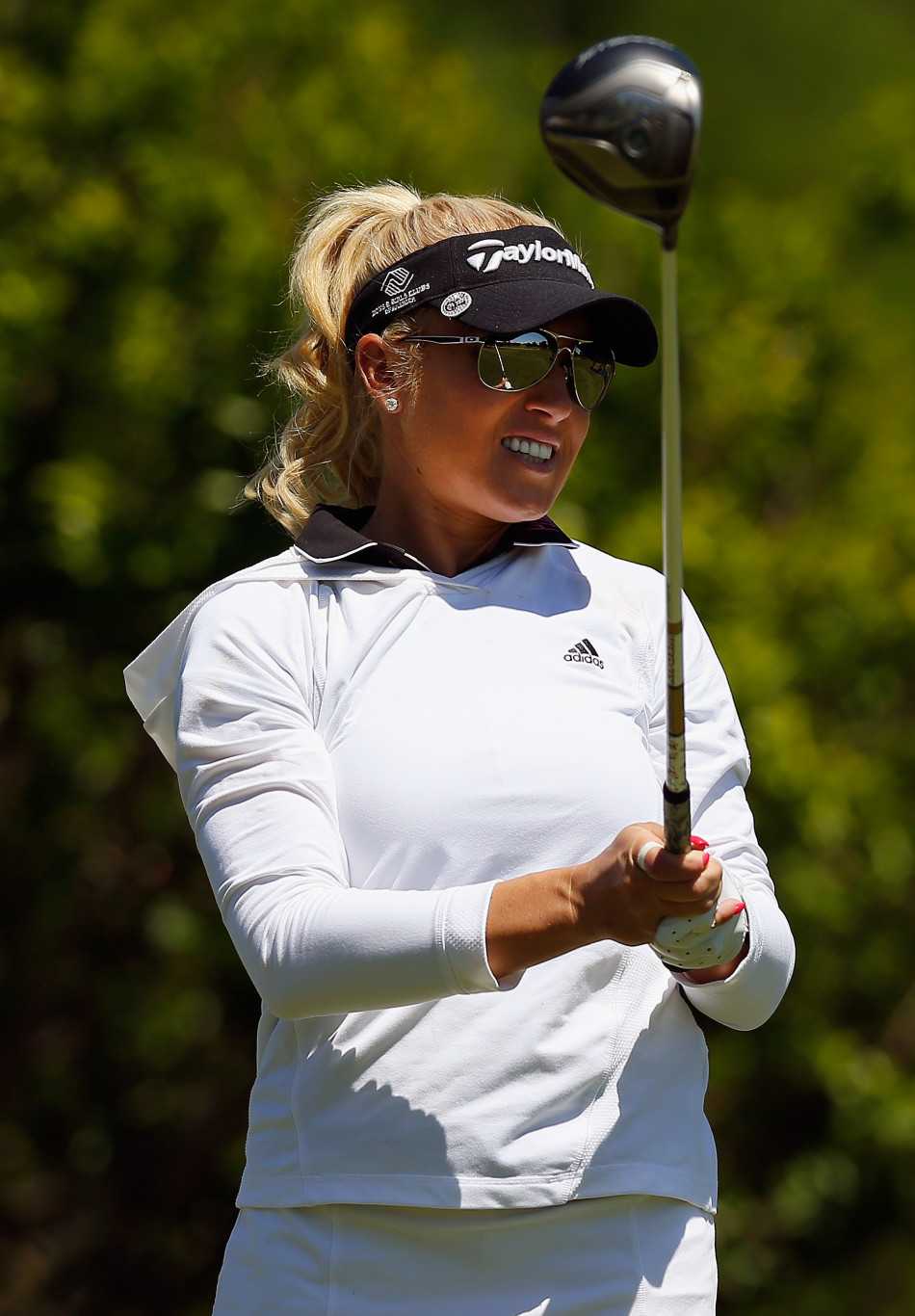 魏圣美在果岭上全神贯注，身体前倾近九十度，以独特的低视角审视推杆线路，神情专注而坚定。