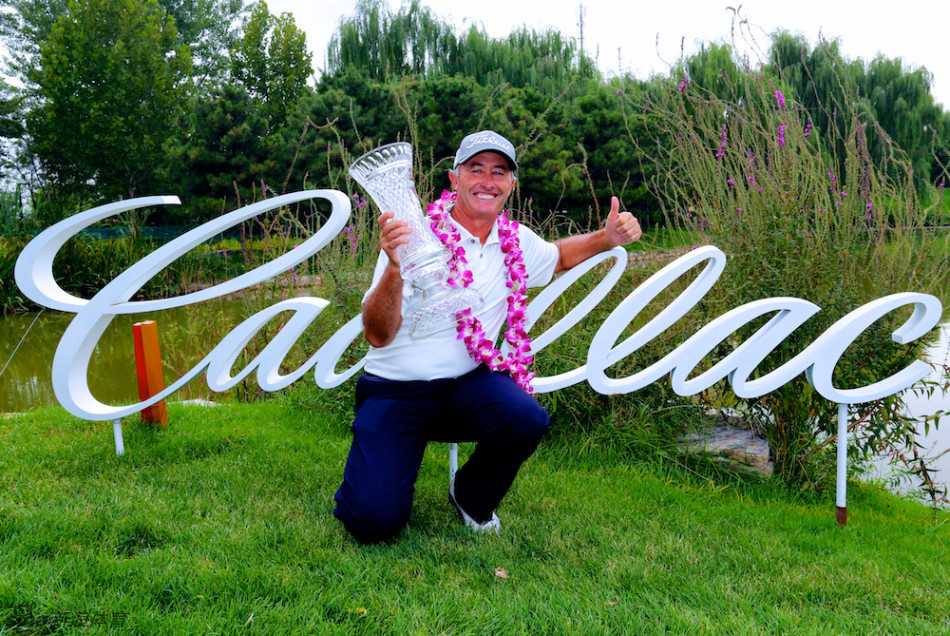 冠军麦肯齐与并肩作战的球童在奖杯前合影，胜利的荣耀属于整个团队。