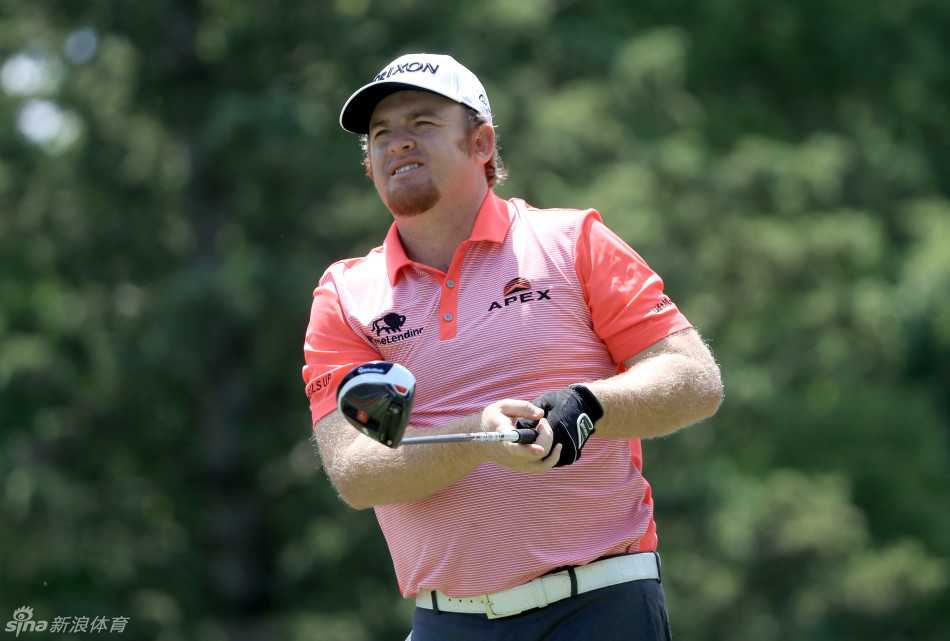 卫冕冠军肖恩·劳瑞在赛场上专注观察果岭线，他正准备应对一次关键的推杆。