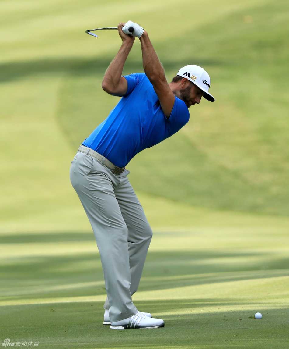 达斯汀·约翰逊在比赛中进行精细的推杆瞄准，神情冷静，对胜利志在必得。