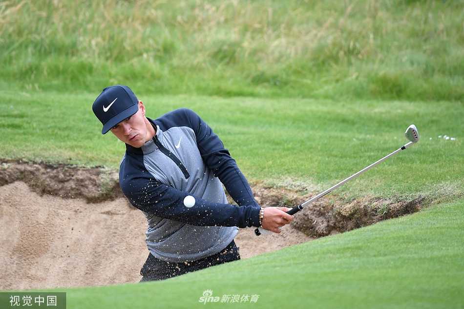 中国高尔夫球员吴阿顺在爱尔兰公开赛练习轮中认真观察果岭起伏，为正赛做最后准备。
