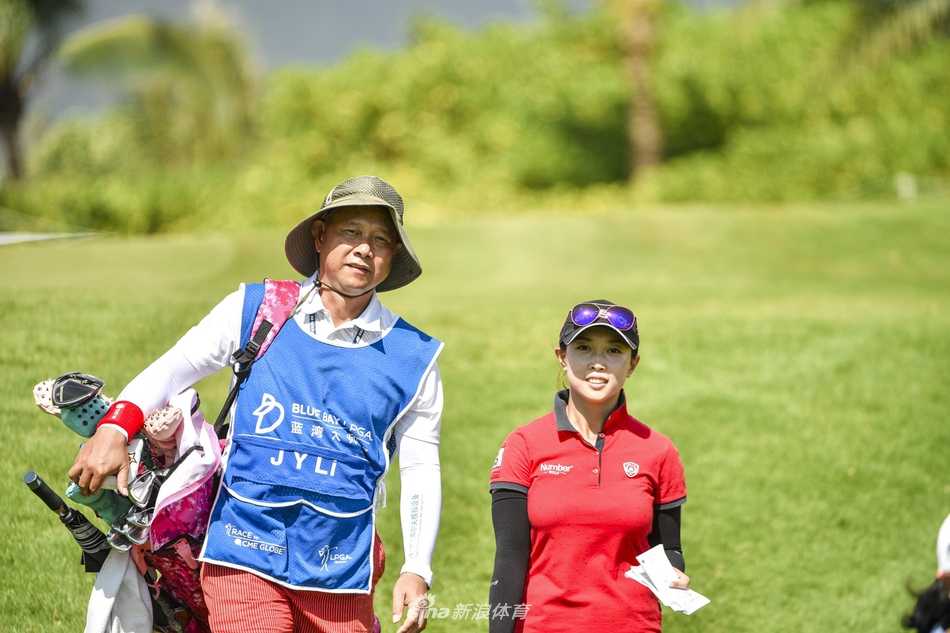 蓝天碧海之间的绿茵球道上，父女并肩前行，共同研判果岭线路，构成一幅合作无间的画面。