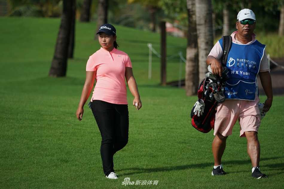 练习果岭边，父女二人凑在一起微笑着研究推杆线路，轻松的氛围中流淌着信任与默契。