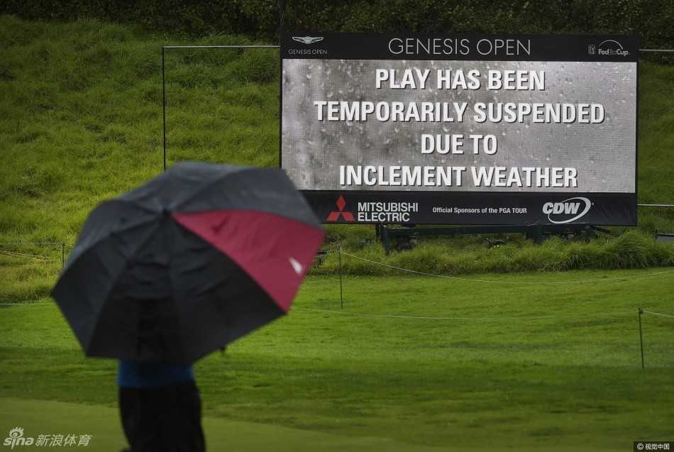 大雨滂沱中，赛事官员高举手臂吹响哨子，背景里穿着雨衣的观众们正匆忙离场，比赛中断的瞬间被定格。