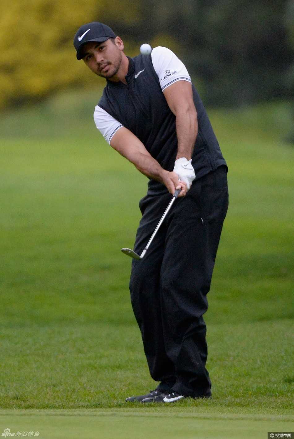 简森·戴伊在湿滑的长草中完成一次艰难的切球，小球溅起水花，飞向被雨水浸透的果岭。