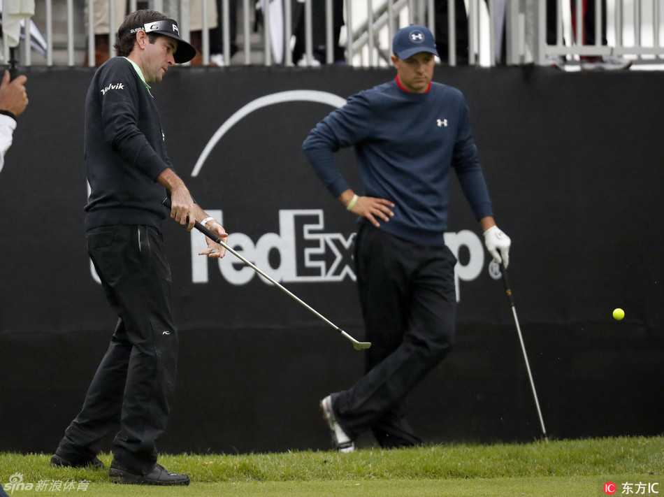 乔丹·斯皮思在发球台沉思，他用手遮在额前望向远方的旗杆，强风吹动了他的衣衫与头发。