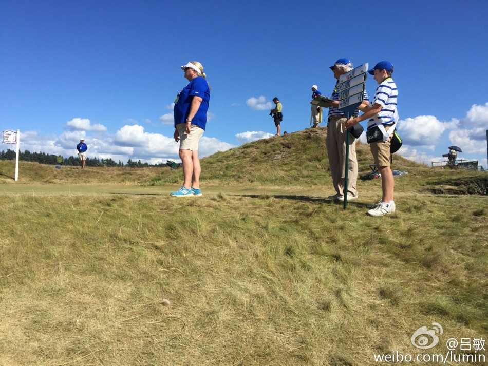 梁文冲与同组球员及球童在记分牌前核对成绩，神情专注