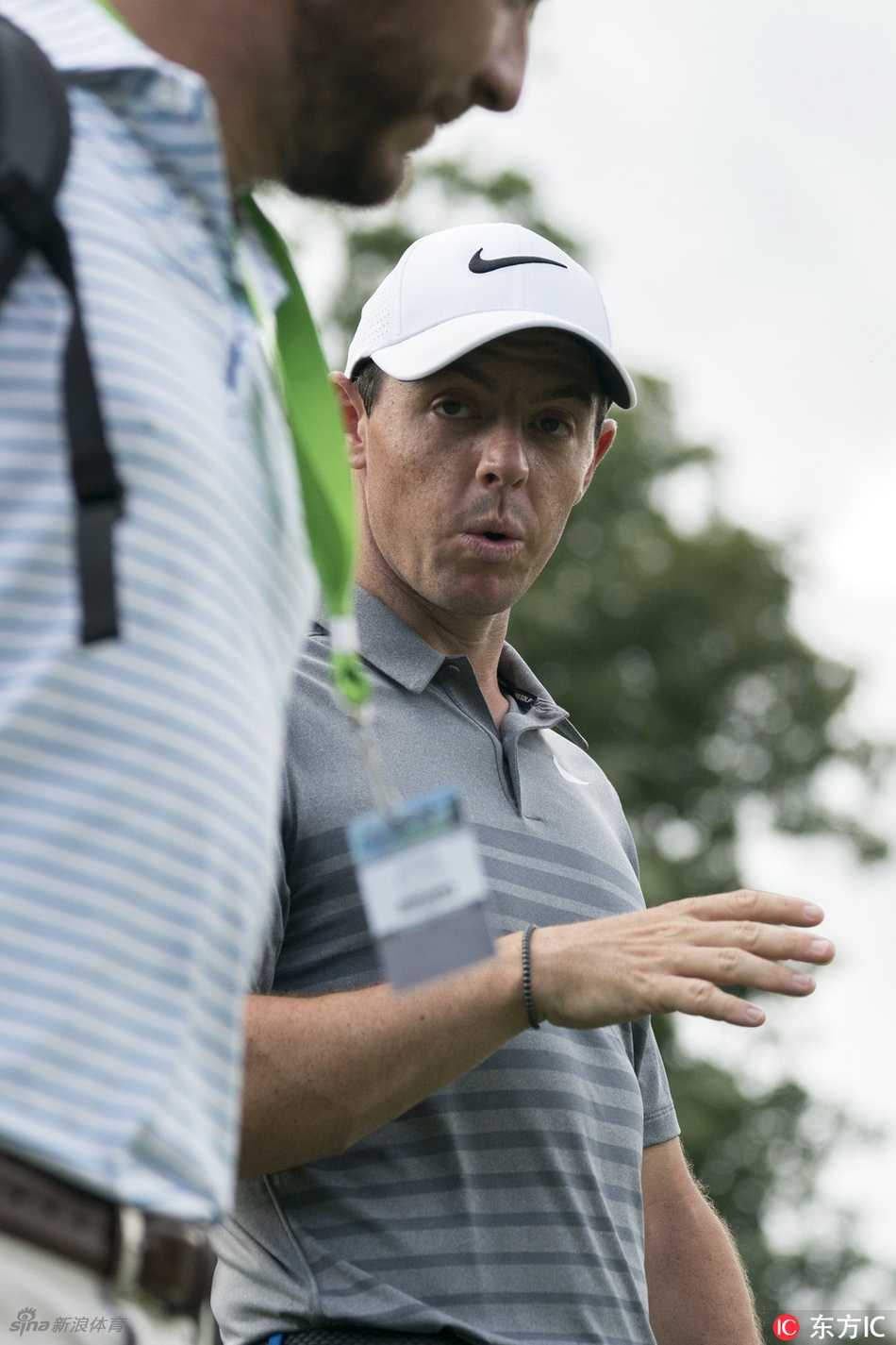 麦克罗伊背负球包凝望远方的果岭，侧影坚毅，仿佛正在沉思如何征服眼前的挑战