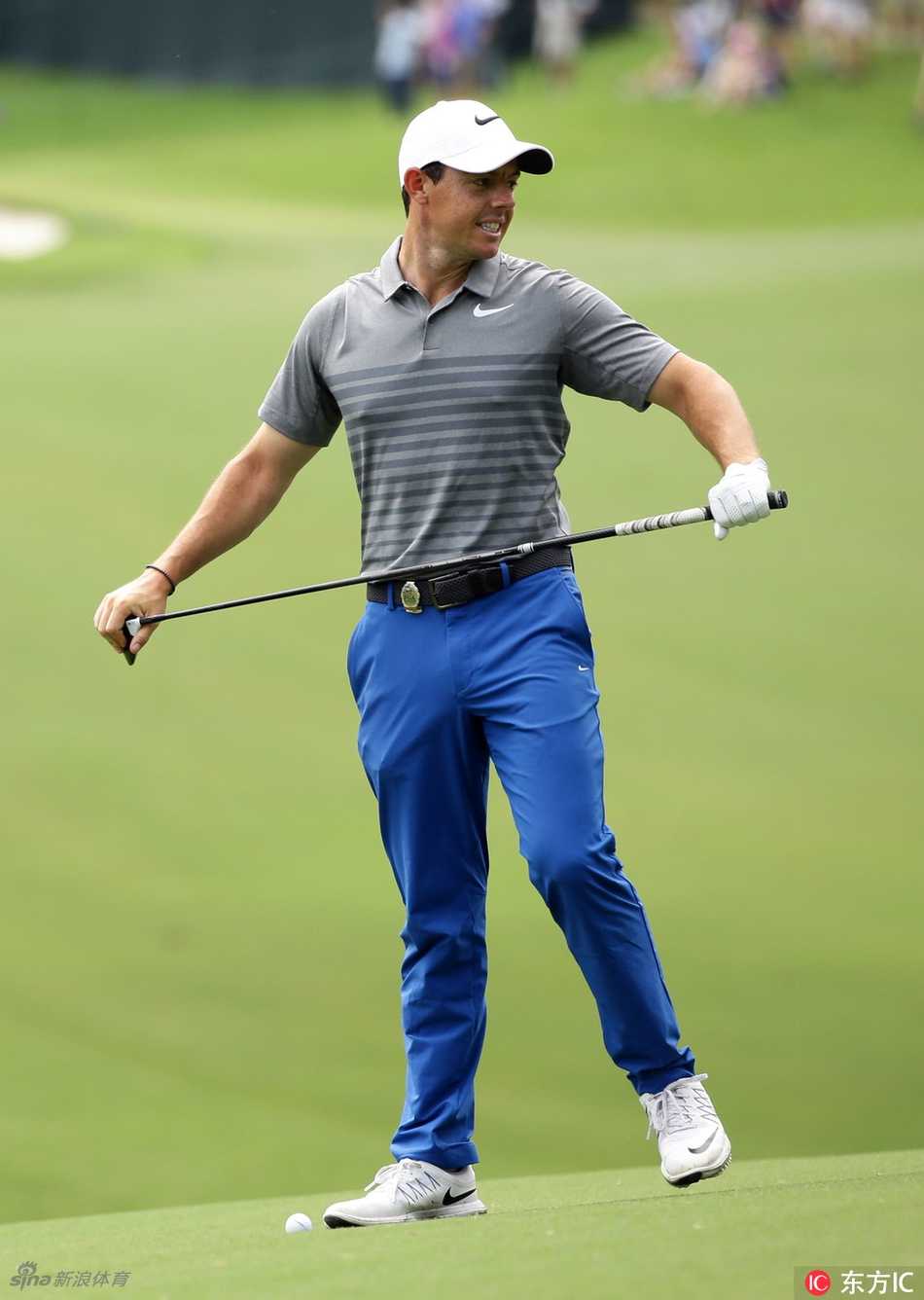 麦克罗伊与他的球童并肩行走在球道上，两人侧头交谈，神情专注而默契