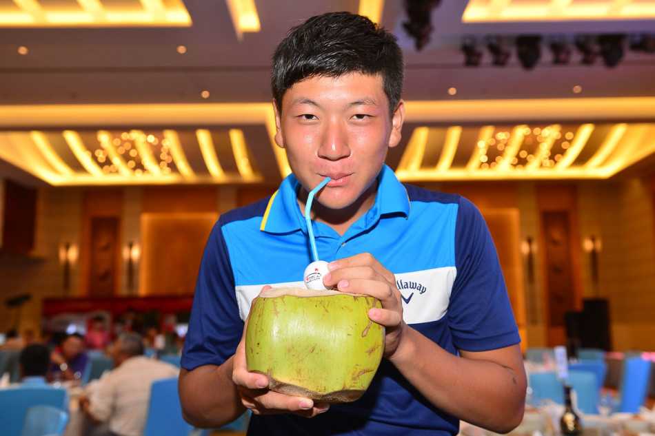 职业球童正专注地为选手擦拭高尔夫球杆，阳光洒在金属杆头上反射出耀眼的光芒