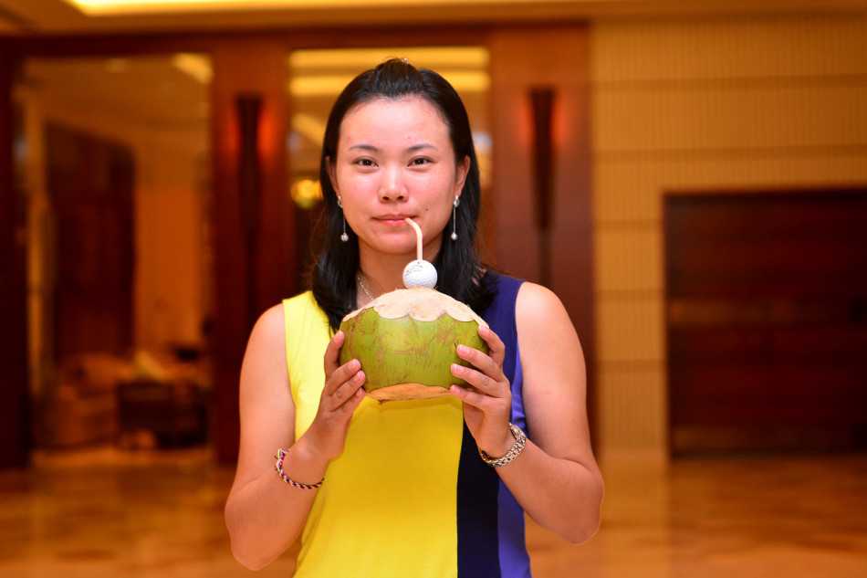 球员们背着球包行走在风景如画的球道上，构成一幅运动与自然和谐相融的画面