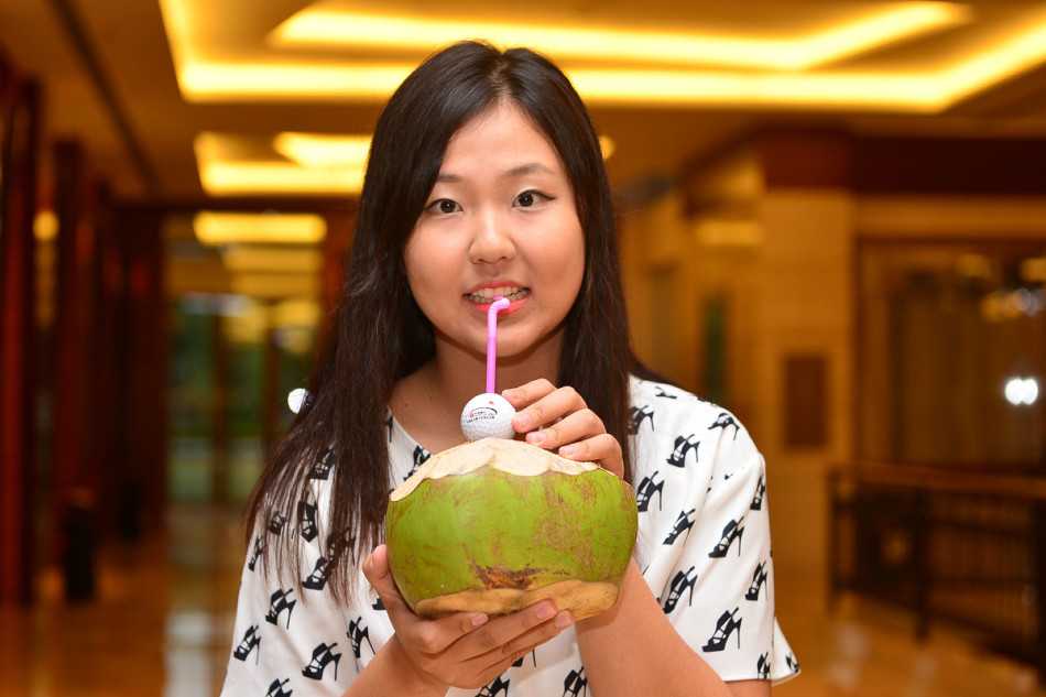 选手在沙坑中冷静分析局势，手握挖起杆准备击球，沙坑边缘绿草如茵