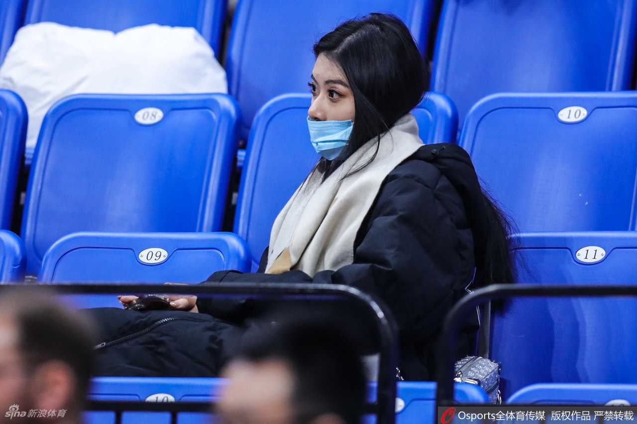 在看台通道处，杨诗尹侧身回眸，一头柔顺的长发披散在肩，脸上洋溢着温婉的笑容，仿佛在与熟人打招呼，展现了江南女孩独有的灵动气质。