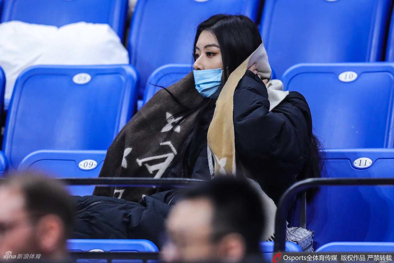 杨诗尹在看台上留下一张美丽的侧影，她单手轻托下巴，眼神望向远方，仿佛在思考着比赛之外的什么，宁静的画面与身后热烈的赛场氛围形成有趣的对比。