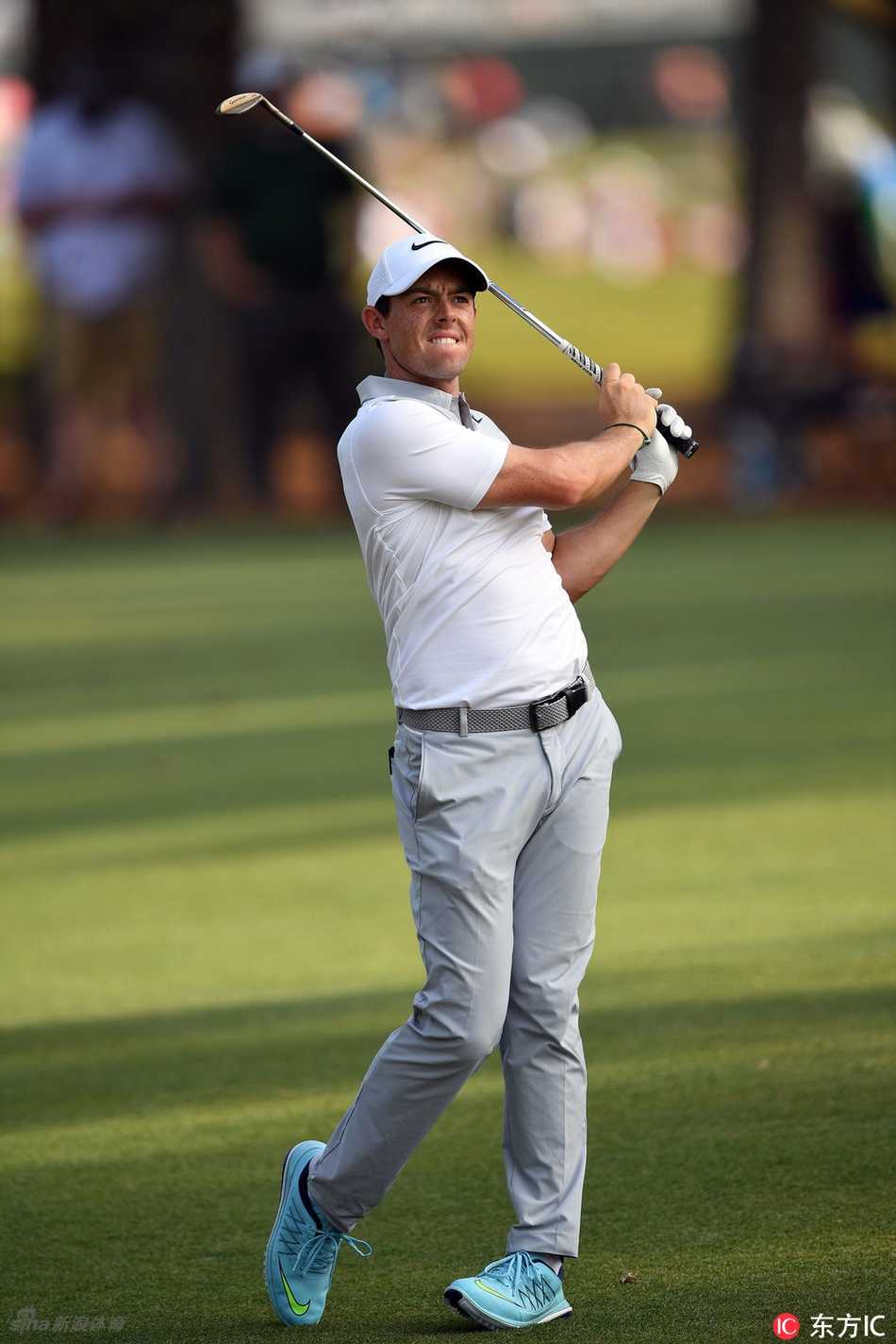 贾斯汀-罗斯在果岭边露出轻松笑容，与球童惬意交谈。