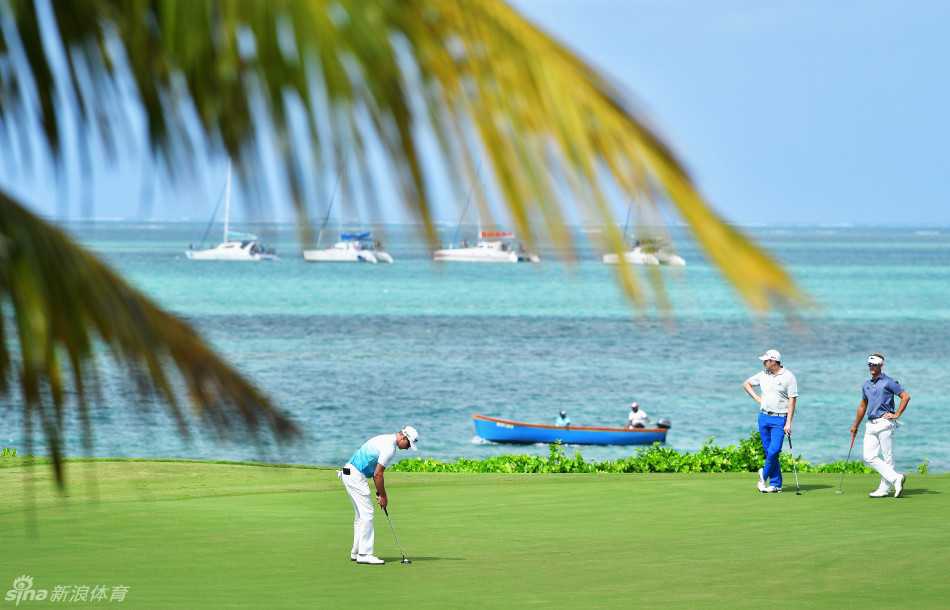 毛里求斯球场全景，蜿蜒的球道如绿丝带般铺展在蔚蓝海岸与苍翠山林之间，美不胜收