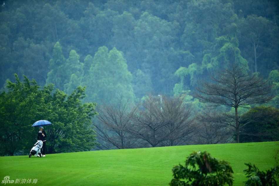 小选手在果岭边仔细研判线路，弯腰凝视，表情认真而专注