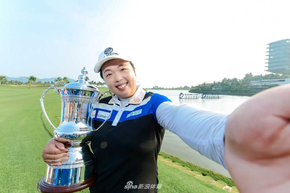 冯珊珊面带标志性微笑，自信而沉稳地推出一记关键推杆，身后是宁静的蓝湾赛场与专注的观众。