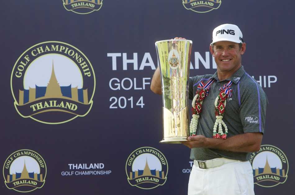 李·维斯特伍德与赛事工作人员在颁奖典礼后手持奖杯亲切合影，现场气氛欢乐融洽。