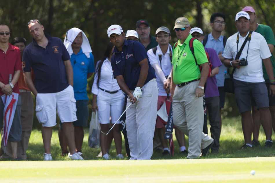 冠军李·维斯特伍德面带微笑，高高举起泰国高尔夫锦标赛晶莹剔透的冠军奖杯，接受全场祝贺。