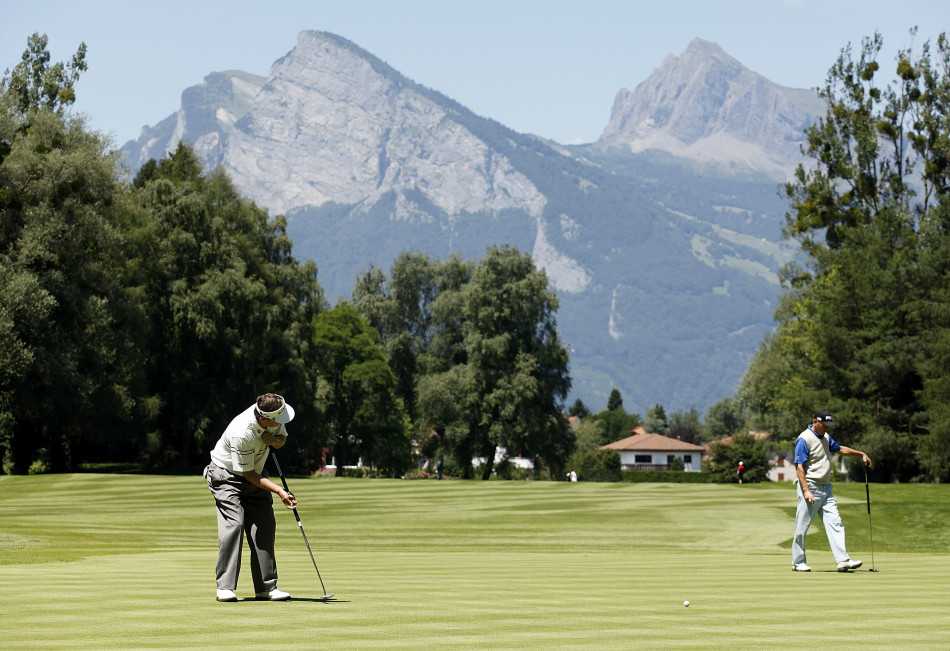 球场养护人员正在精心修剪果岭边缘，展现世界级球场对每一寸草坪的极致呵护。