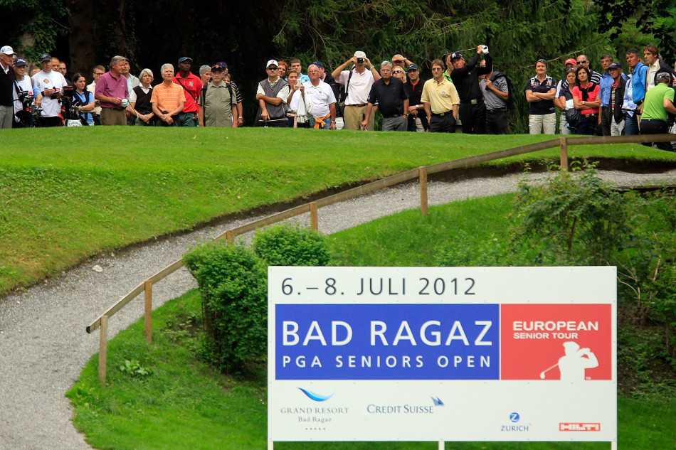 赛事观众聚集在果岭周边，聚精会神地观看关键推杆，现场充满了紧张而专注的气氛。