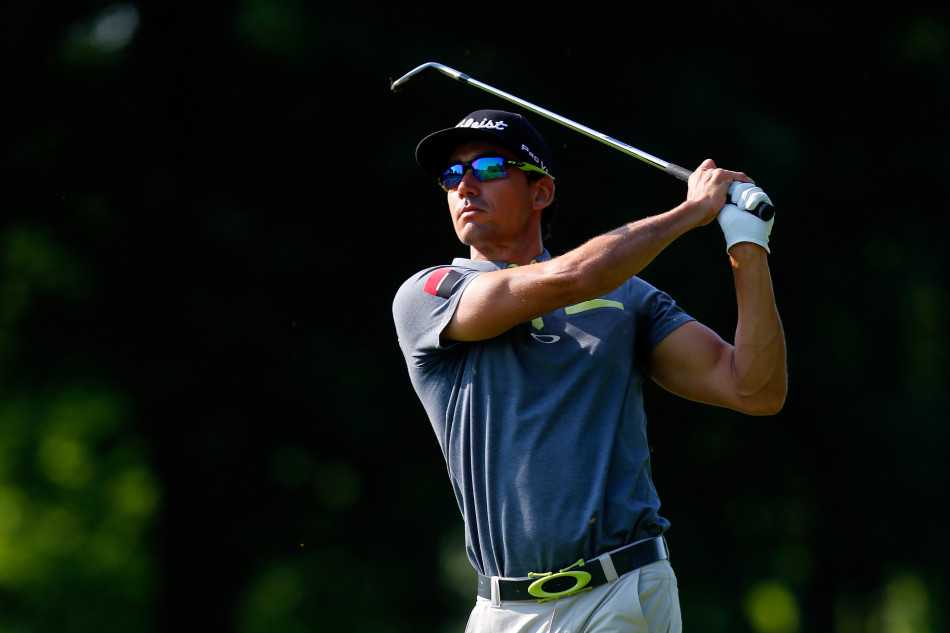 卡布雷拉-贝罗与球童并肩观察果岭地形，两人指指点点，正在进行一场关于坡度与草纹的精密对话。