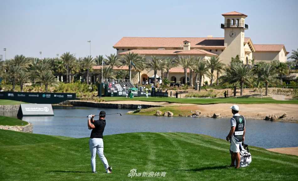 达斯汀-约翰逊在开球台上大力开球，白色小球在蓝天背景下划出一道有力的弧线。