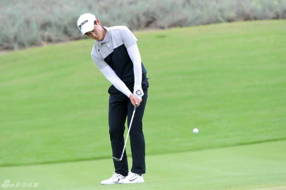 球员在沙坑中救球，沙粒飞扬，展现出高尔夫运动中挑战障碍的精准与力量