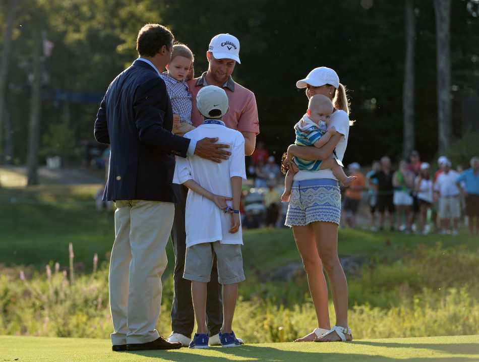 科克一手紧握奖杯，一手指向支持他的观众席，向所有见证他胜利的人致意。