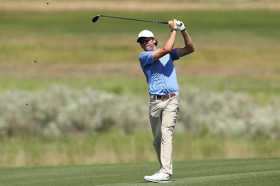 球员在果岭边仔细俯身观察推杆线路，神情专注如雕刻家审视作品