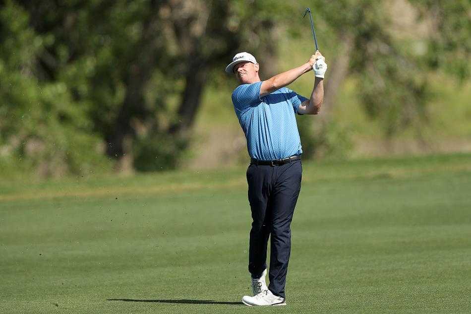 两位球员与球童在球道中并肩前行，边走边深入讨论下一杆的策略