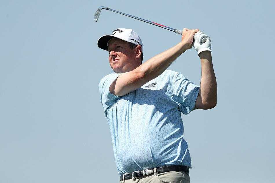 球手侧身面对镜头，在完美修剪的球道上完成一次标准的铁杆击球