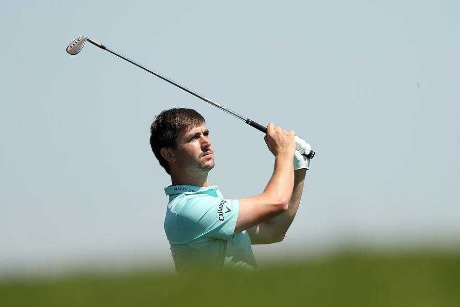 球迷聚集在风景如画的湖岸边，凝神观看球手在临水球洞的精彩对决