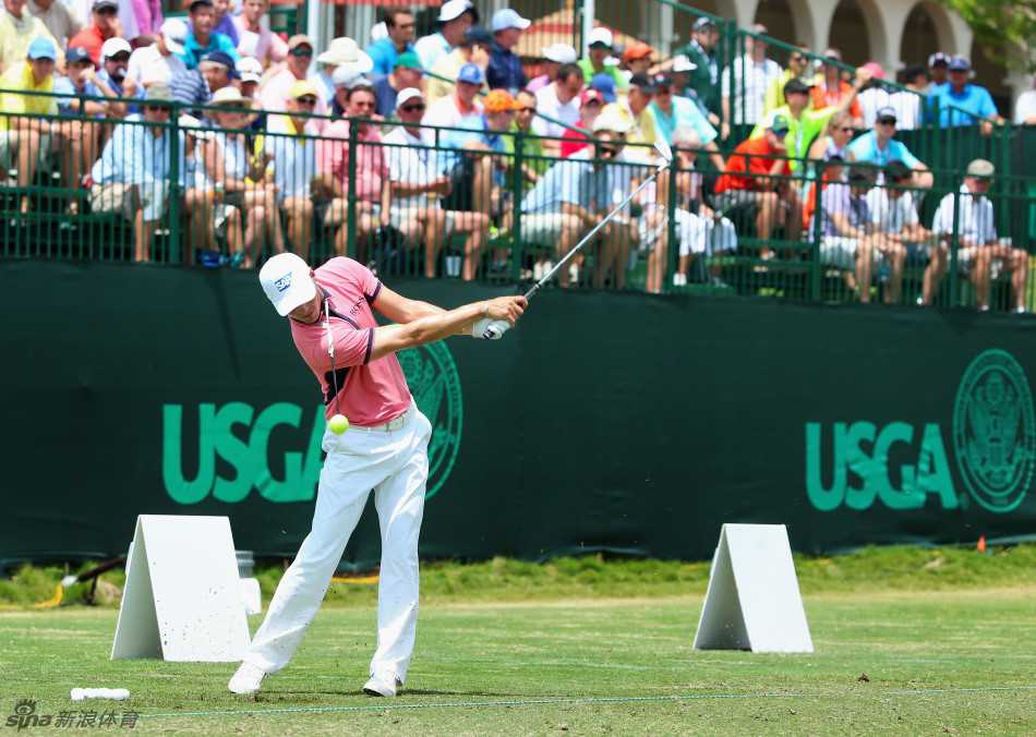 塞尔吉奥·加西亚与他的球包并肩而行，装备整齐的职业球员正在走向练习场，神情中充满了对即将到来比赛的专注与思考。