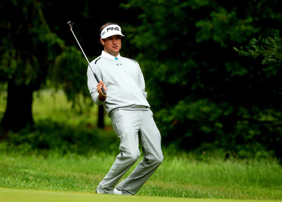 巴巴沃森在果岭边专注看线，他蹲下身姿，目光如炬地审视着推杆线路的每一寸起伏