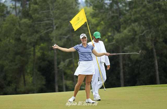 传奇球星巴巴·沃森身着象征大师赛冠军的绿夹克，亲临奥古斯塔国家女子业余锦标赛现场，面带微笑专注地观赛，彰显了赛事获得的至高关注与支持。
