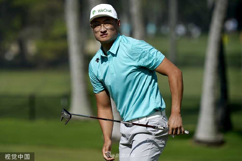 松山英树在碧海蓝天背景下进行关键性劈起杆击球，神情冷静而专注