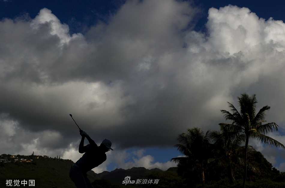 夕阳余晖洒在球场，一名球童为球员递上球杆，勾勒出高尔夫运动的协作与宁静之美