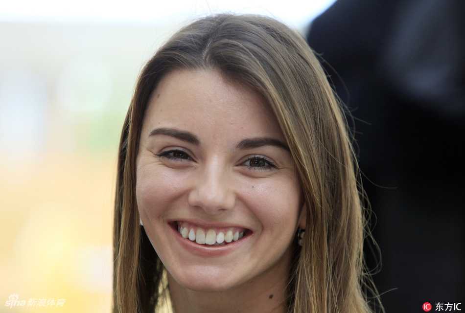 克拉拉·斯皮尔科娃身着简约运动装，手持推杆于布拉格古老石桥畔凝神远眺，身后是静静流淌的伏尔塔瓦河，尽显专注与宁静之美。