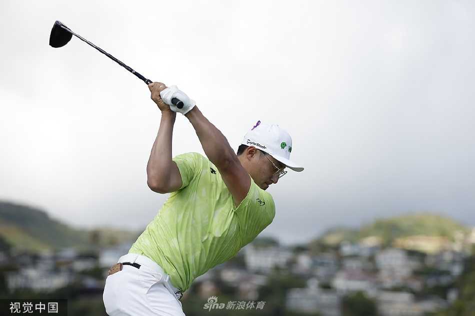 松山英树在球道中冷静分析下一杆策略，身旁的球童正与他进行细致沟通。