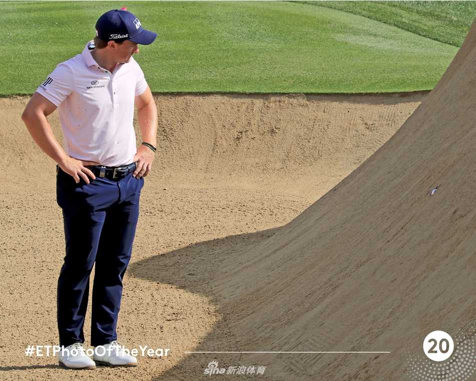 沙坑救赎：球员半跪沙中奋力击球，沙粒飞扬如金雾，展现绝境中的技艺