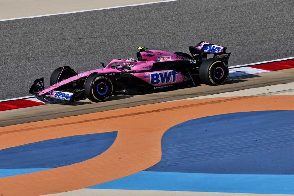 阿隆索的阿斯顿·马丁赛车在弯角中紧咬前车，绿色幽灵蓄势待发，准备上演超车好戏。