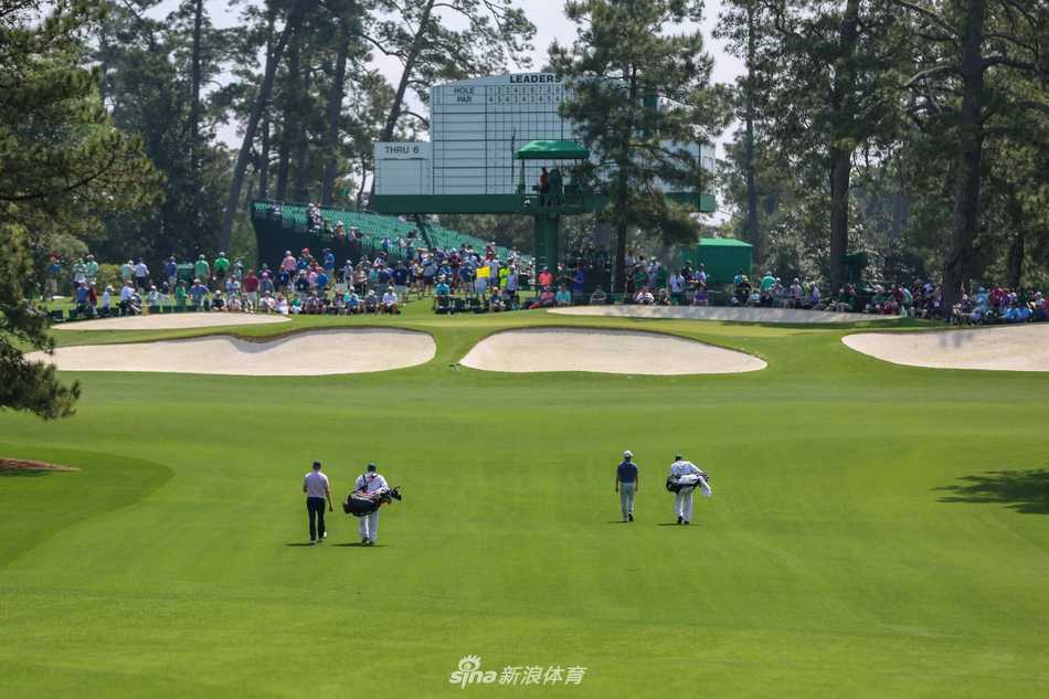 夕阳为奥古斯塔著名桥洞镀上金边，两名球员漫步而过，画面宁静如古典油画