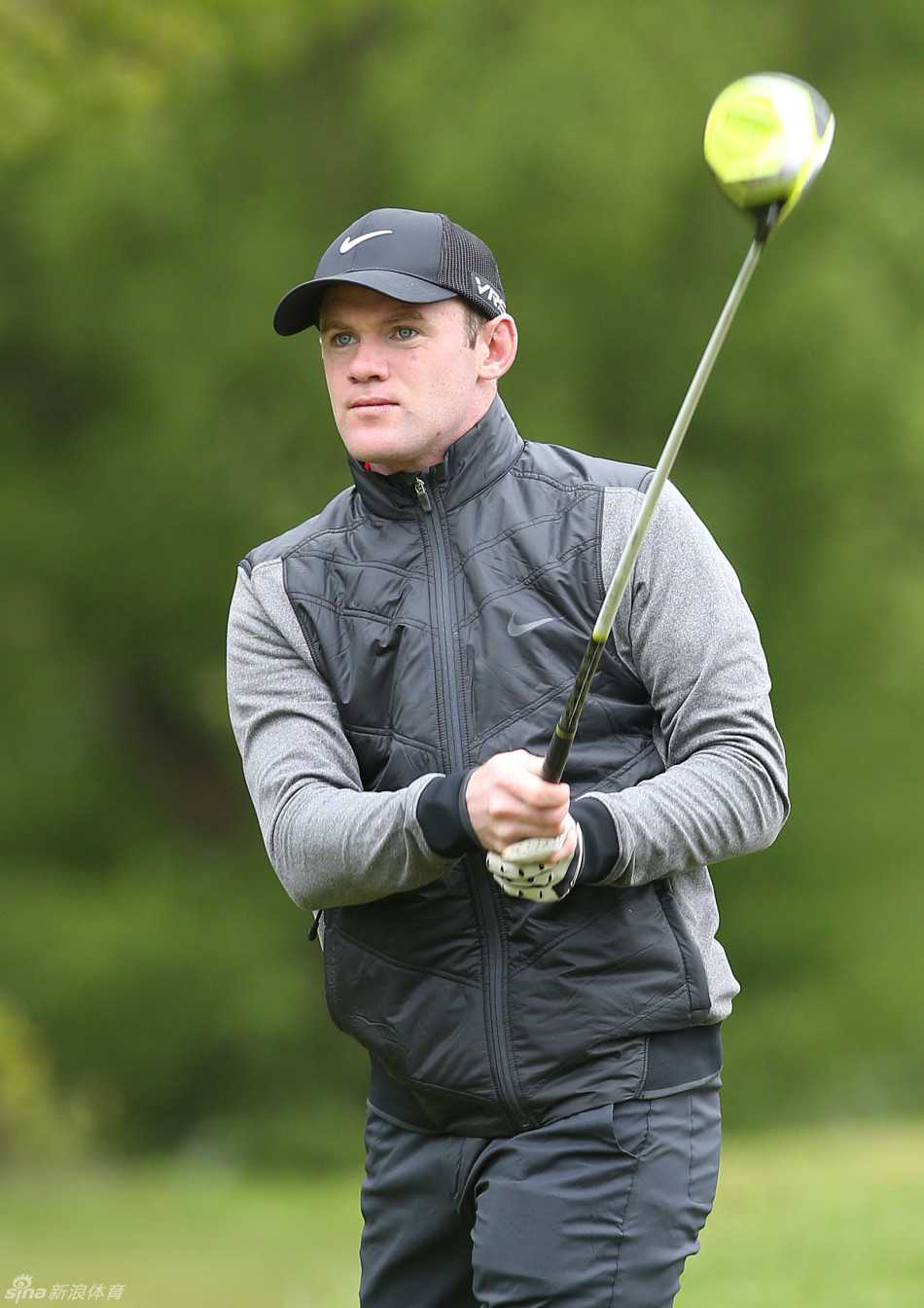 鲁尼手搭凉棚，专注地眺望着高尔夫球飞行的轨迹，神情认真，仿佛在绿茵场上观察战局。